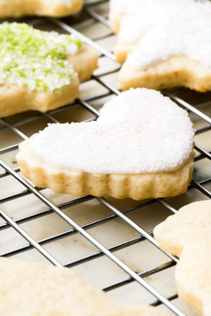 Close up texture of the edge of the sugar cookie shaped like a heart and frosted white