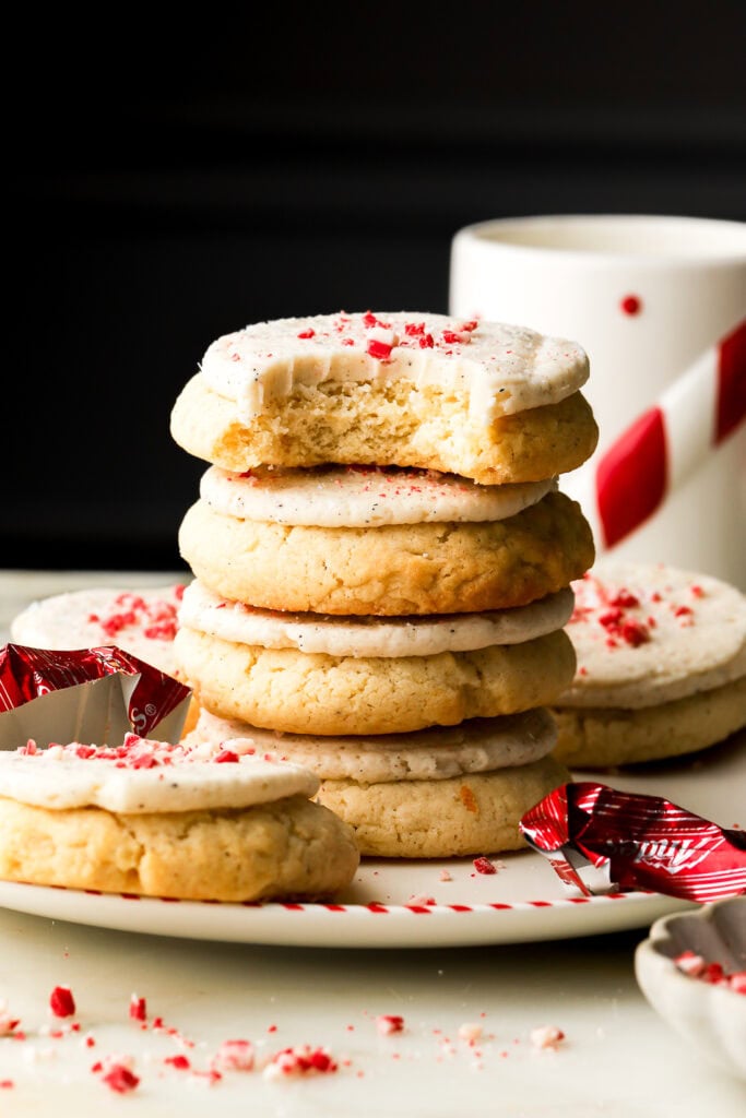 peppermint sugar cookies stacked next to a candy cane mug