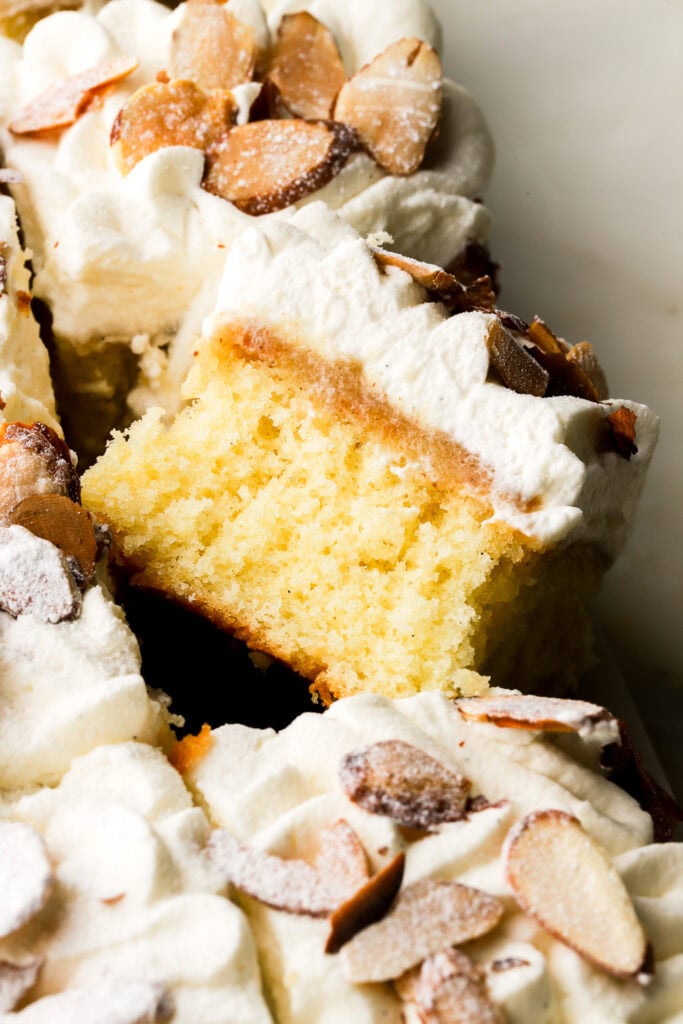 almond croissant sheet cake sliced and showing the inside, topped with toasted almonds