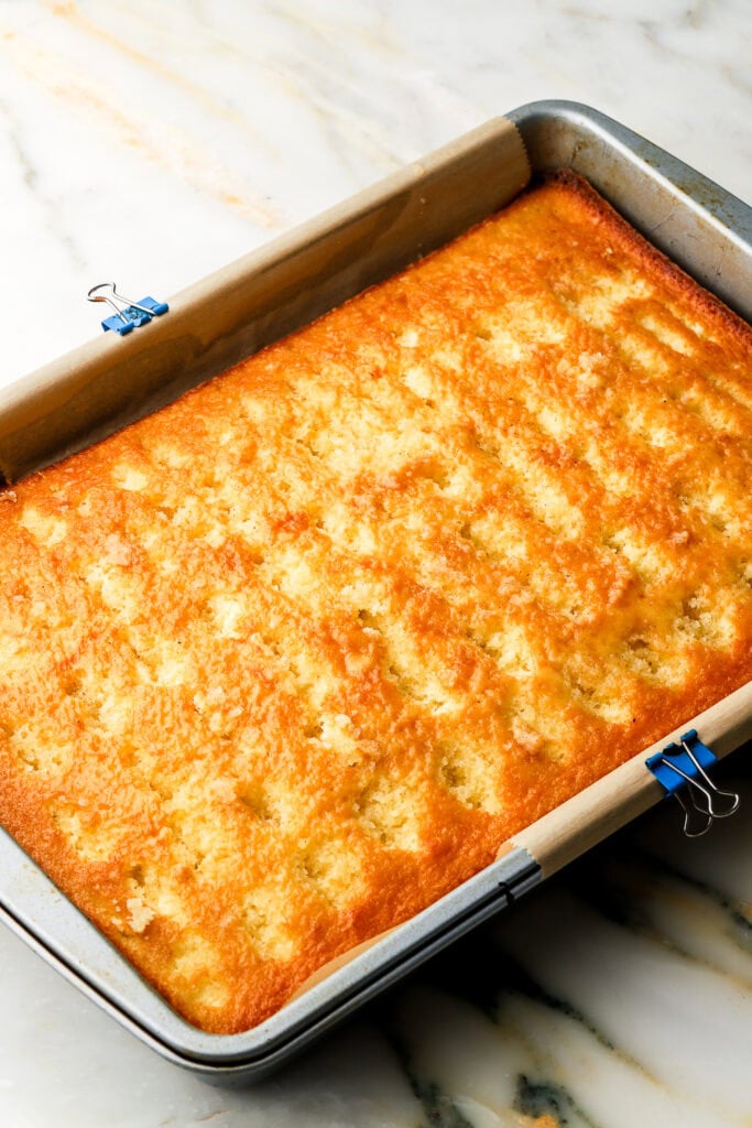 Hot Milk Sponge with fork holes poked in it and topped with almond syrup