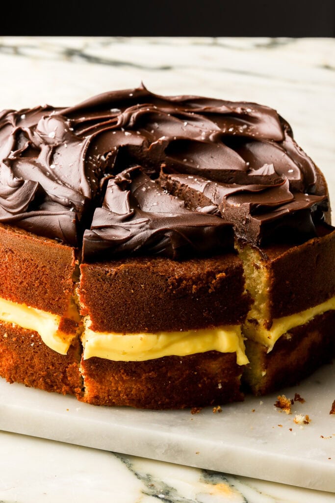 boston cream pie on a marble board and sliced