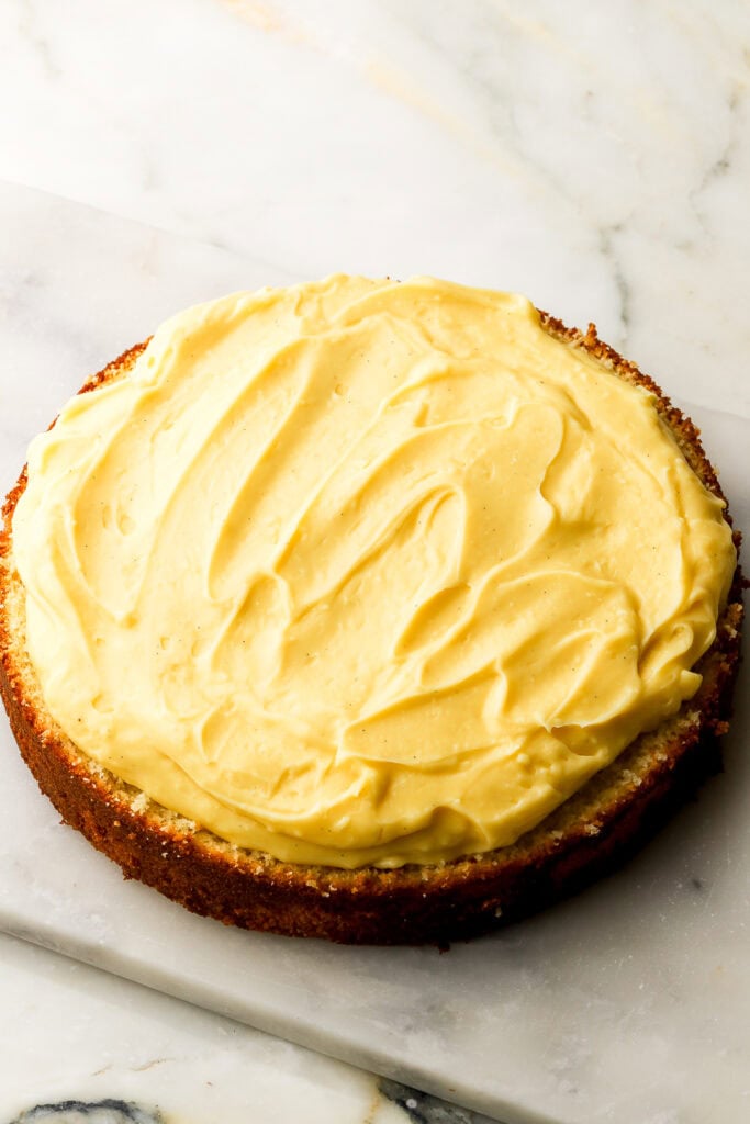 pastry cream spread on top of the bottom layer of cake