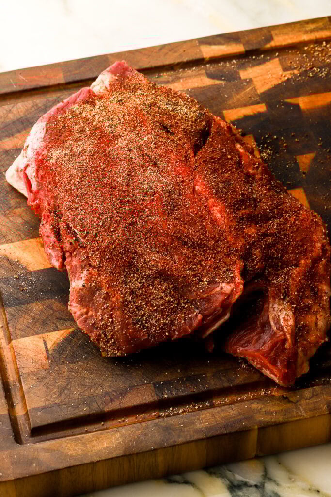 beef chuck roast on a cutting board, patted dry and well seasoned