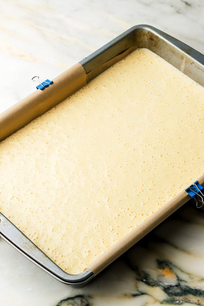 hot milk sponge cake batter in a prepared 9x13" pan