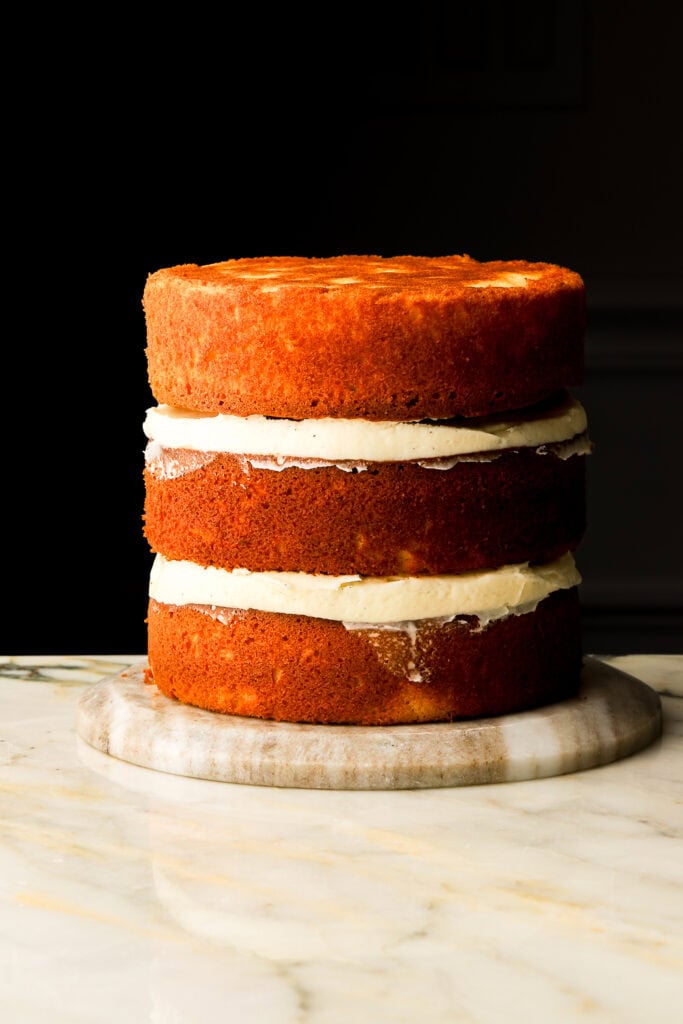 three layers of vanilla cake layered with vanilla frosting, not frosted yet