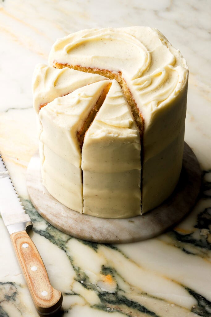 6 inch vanilla cake frosted with american buttercream and sliced but still together