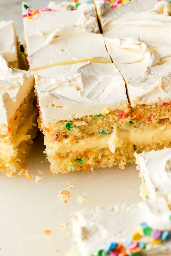 birthday cake on a board  with slices cut to show the inside