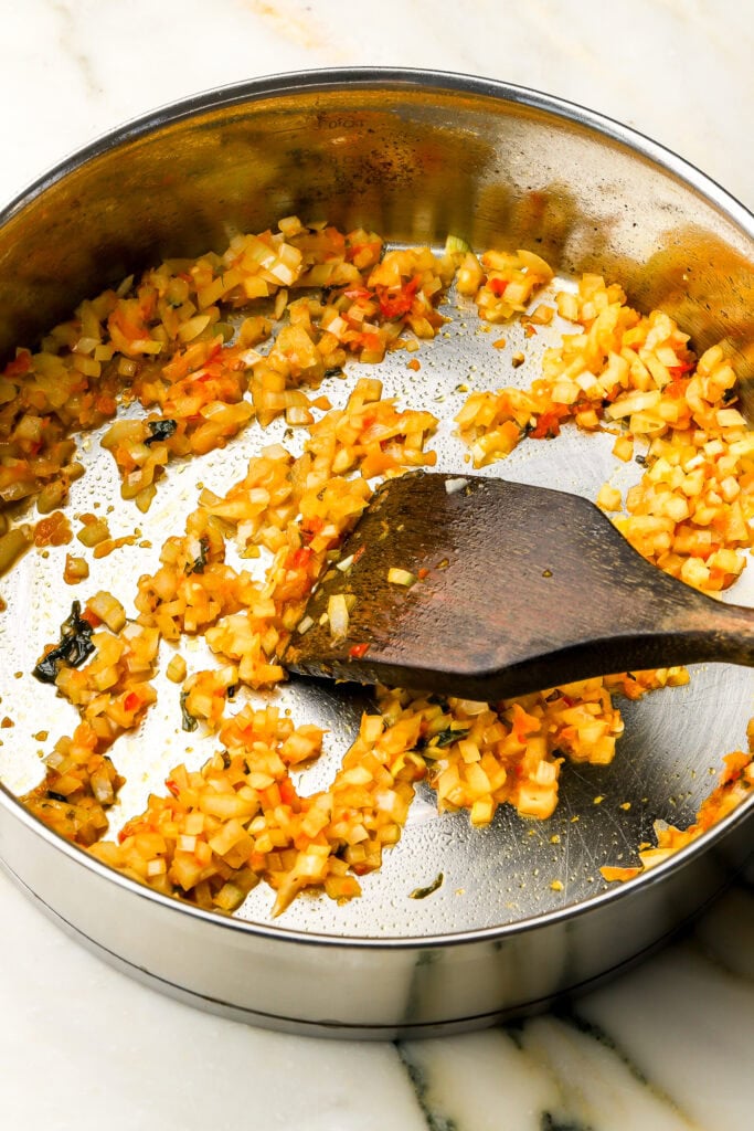 onions, bell peppers and garlic sauteed in a pan