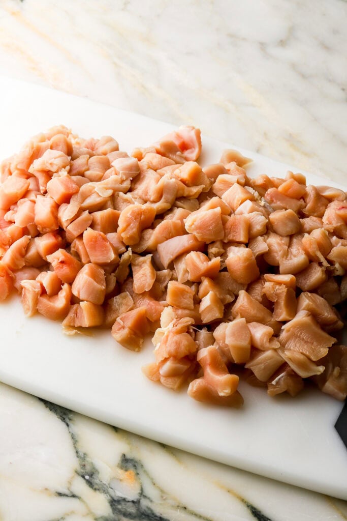chicken diced into small cubes on a cutting board