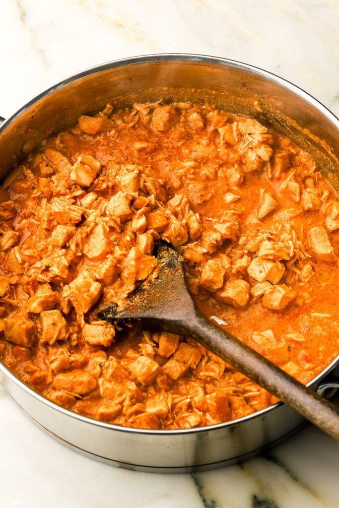 tocanita finished cooking with sauce thickened in pan with a wooden spoon