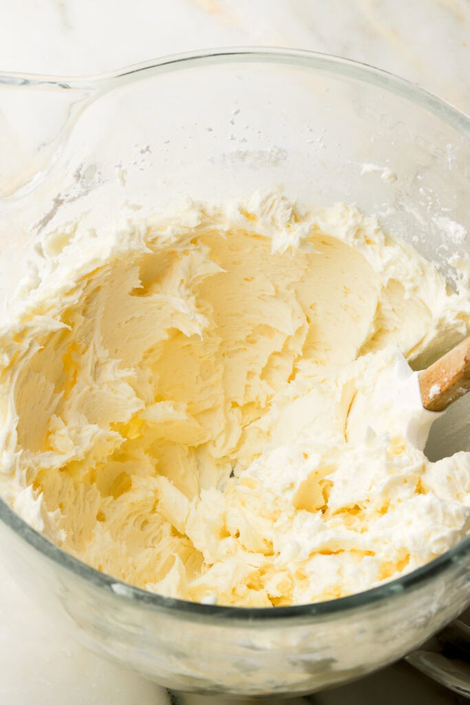 buttercream finished but stiff in a glass bowl with spatula