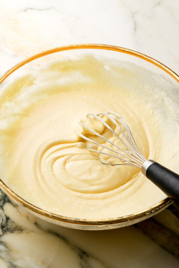 eggs mixed into coffee cake batter in a glass bowl