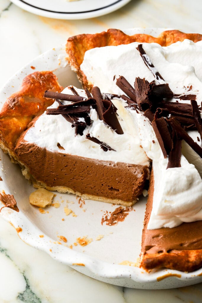 french silk pie sliced in pie dish, showing side texture of cream