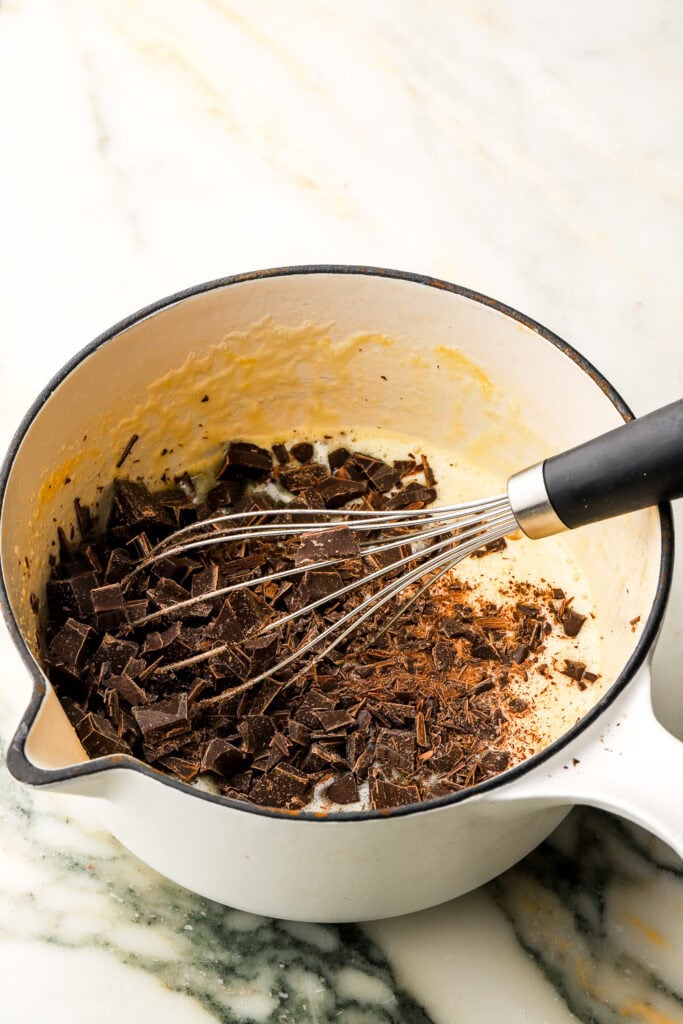 chocolate added to a pot with eggs, sugar and whisk