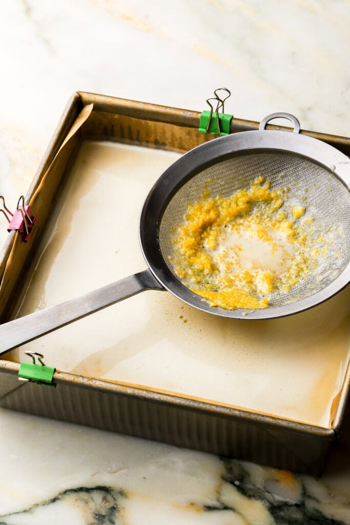 lemon filling pressed through a strainer over the par-baked crust