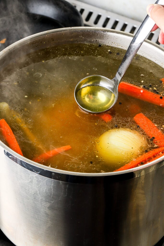 ladle pulling up the soup, showing the golden color