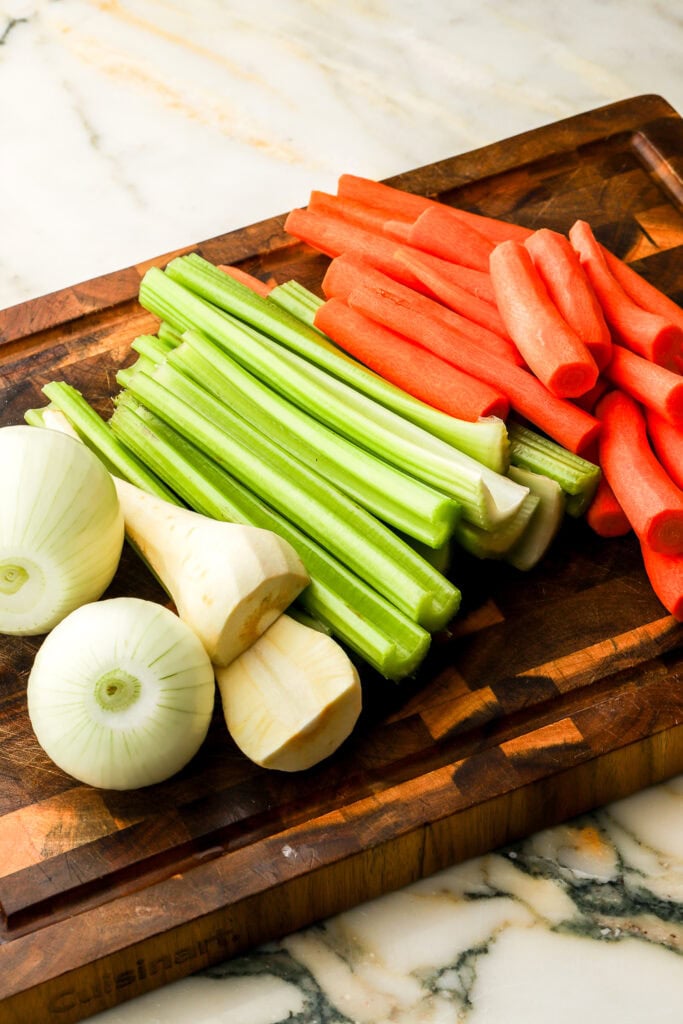 vegetables peeled and sliced in half on a cutting board