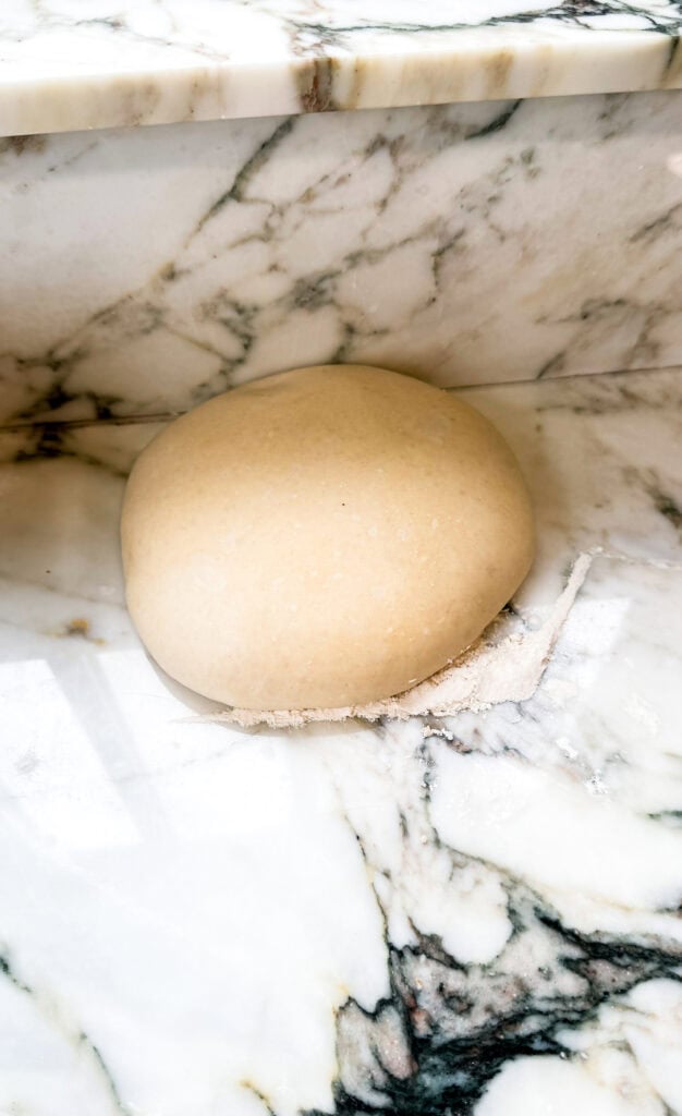 hand stretched dough ball proofed on the counter