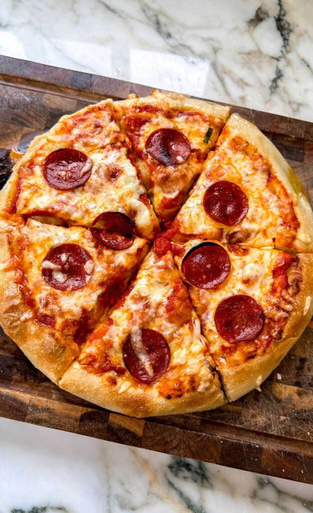 pan pizza finished baking with pepperonis on top