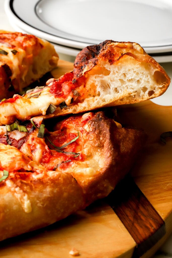 hand-stretched pizza sliced showing side profile of crust