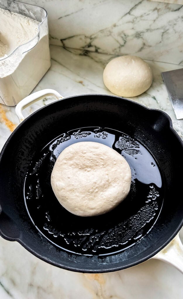 1 dough ball proofing on the counter and one in the prepared pan