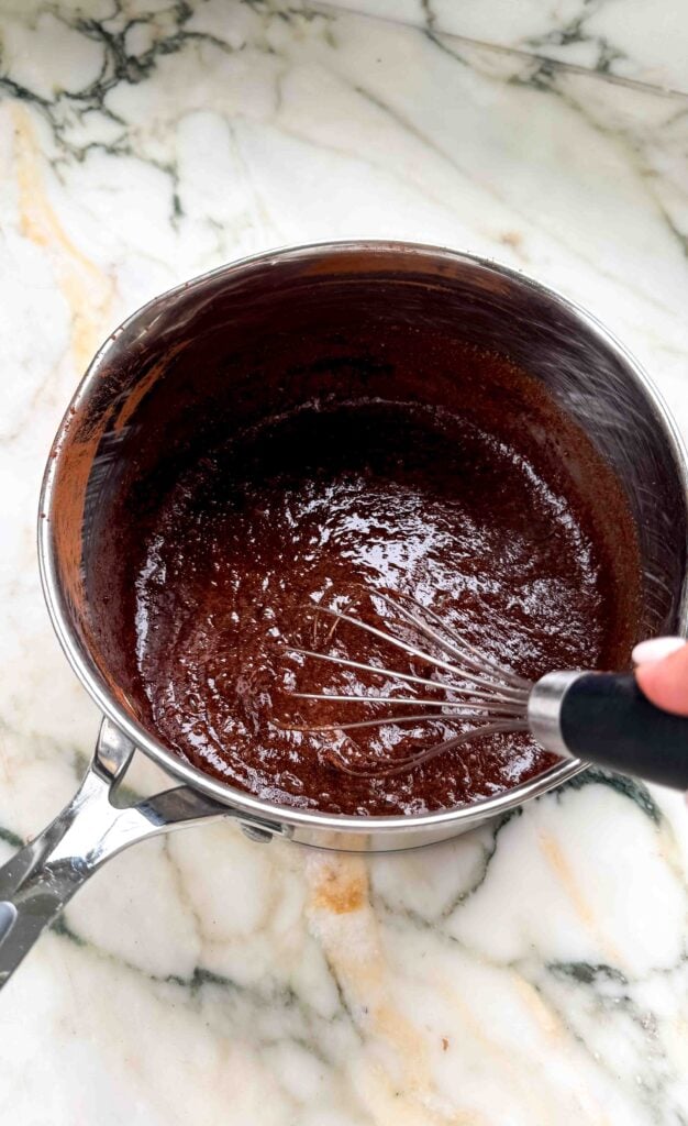 ingredients for chocolate custard getting whisked in a saucepan