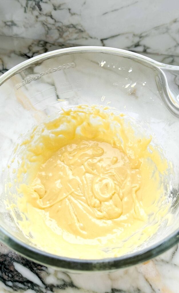 flour and butter mixed into the egg yolks in the glass bowl of a stand mixer