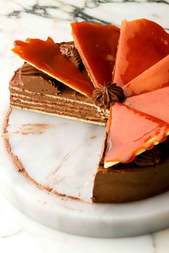 dobos topped with caramel triangles - several slices removed showing the inside of the cake
