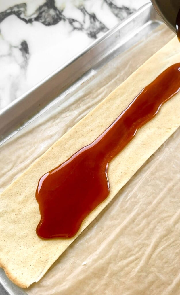 caramelized sugar being poured on top of the last layer of cake