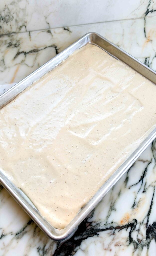 brown butter batter spread into prepared pan on a marble countertop 