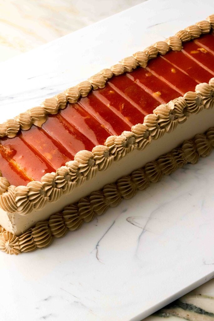 finished coffee dobos with caramel topping scored and piping around the edge