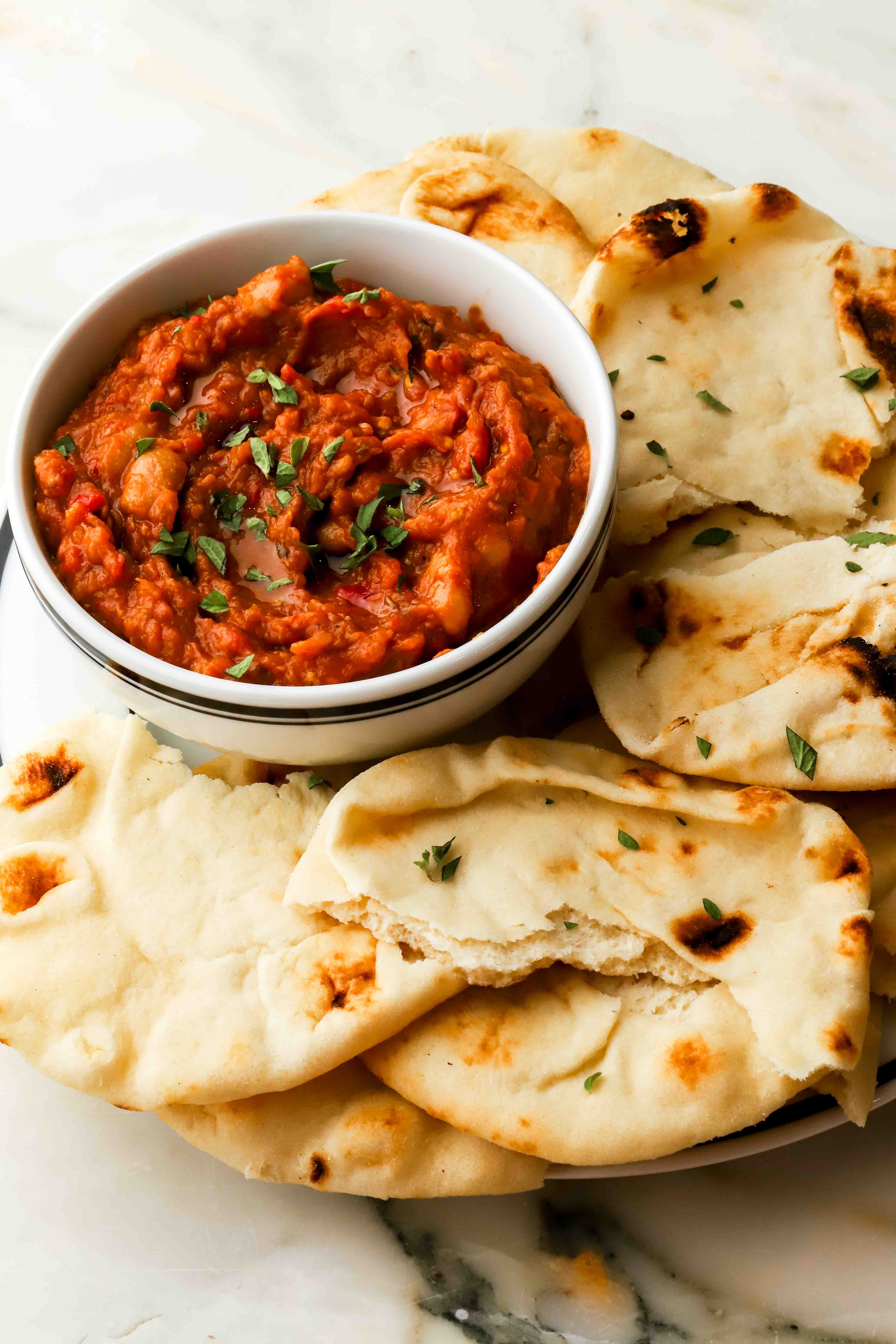 bowl of zacusca on a plate with naan bread